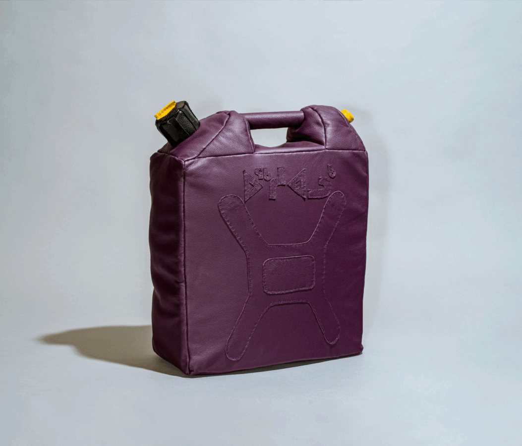 A soft, rectangular bag shaped like a jerry can, made of deep purple leather with stitched details resembling a fuel container. The top has a short handle and a black cap with a yellow accent.